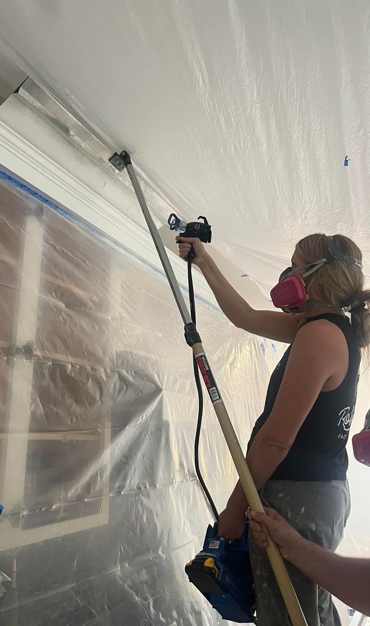 Roll With It painter spraying an interior finish