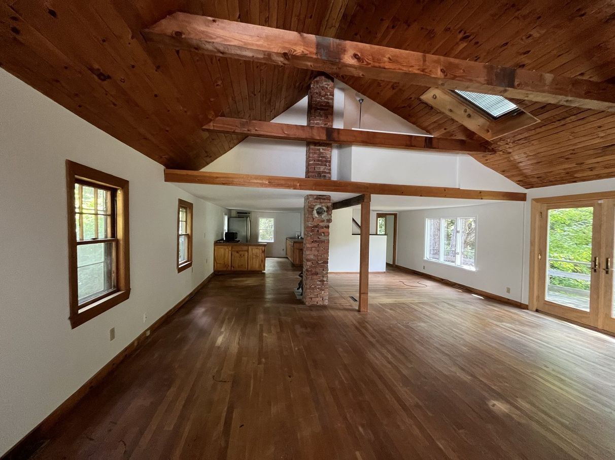 Great room with painted walls and exposed wood beams