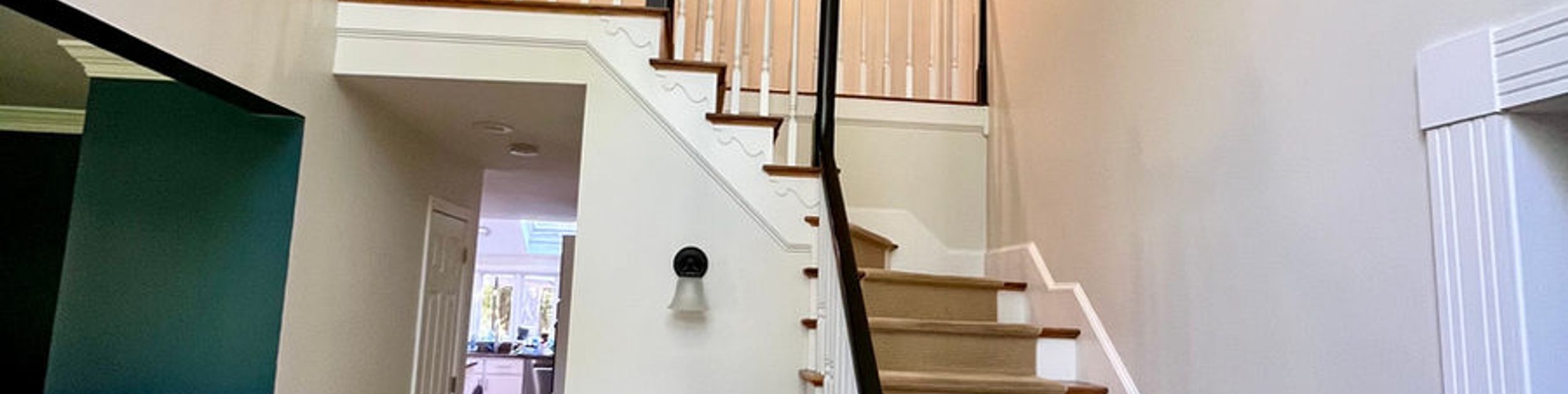 Painted stairwell with white balusters and dark railings