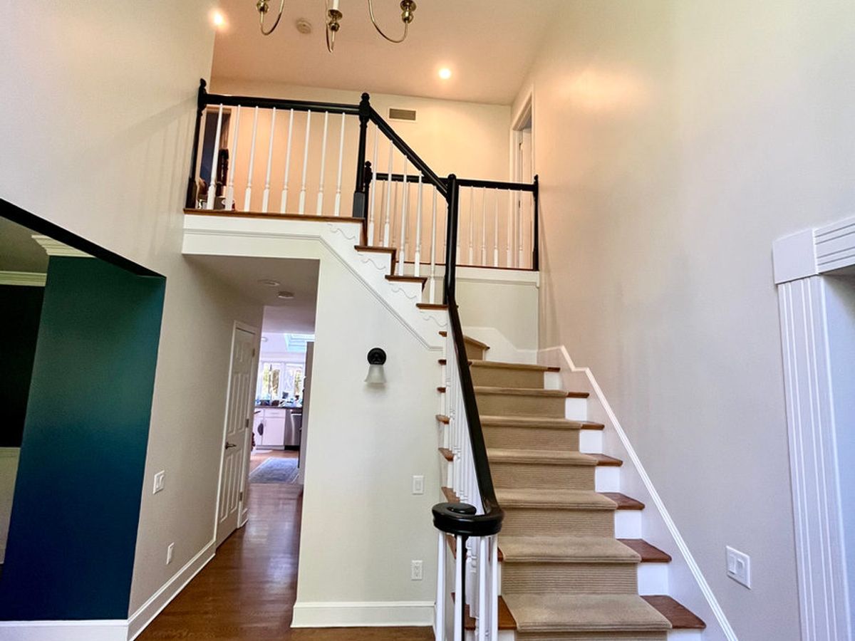 Freshly painted stairwell with white balusters and dark railings